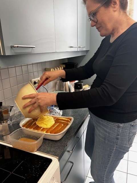 Teilnehmerin des Italienischkurses an der VHS Baden bereitet im Rahmen einer praxisnahen Unterrichtseinheit ein originales Tiramisù zu